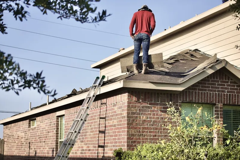 Professional roofer working on a residential roof in Wood Village Green Mobile Home Park